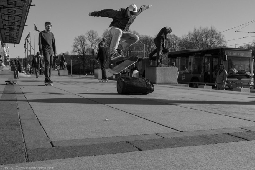 Skateboarding outside Oslo City Hall. Kick flip over a garbage bin.